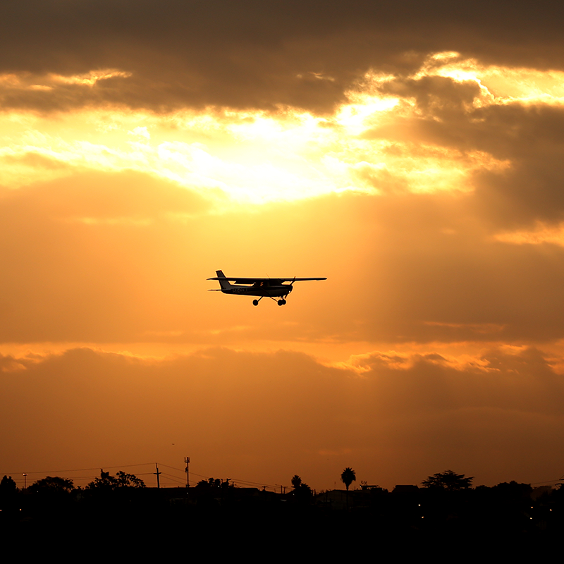 Airplane flying at sunset